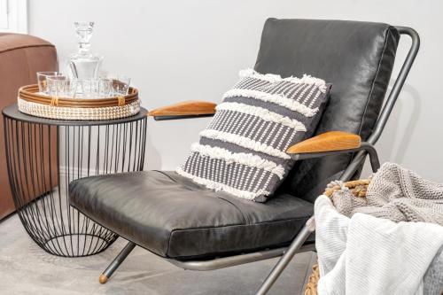 a black leather chair with a side table in a room at Hall House in Bowral