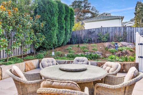 a patio with a table and chairs in a backyard at Hall House in Bowral