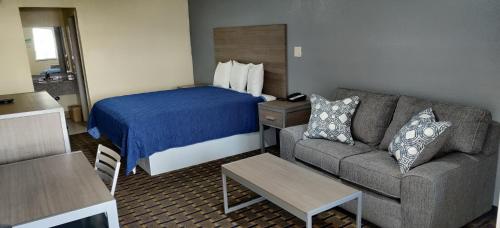 a hotel room with a bed and a couch at Ameristay Inn & Suites in Orange