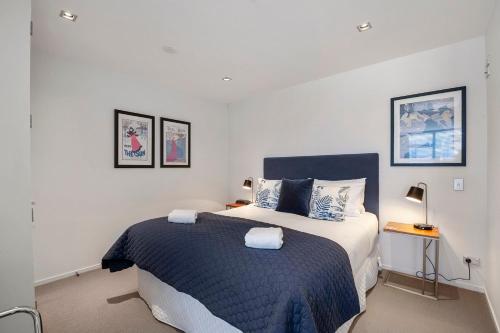um quarto com uma cama grande e um cobertor azul em Waimahana Apartment 12 em Taupo