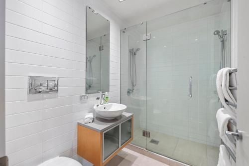uma casa de banho com um lavatório e uma cabina de duche em vidro. em Waimahana Apartment 12 em Taupo