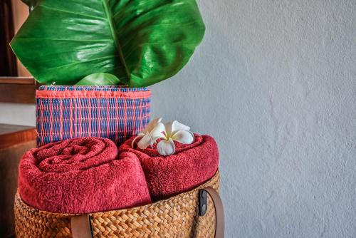 uma cesta com toalhas vermelhas e uma planta verde em Sugar and Spice Inn em Kata Beach