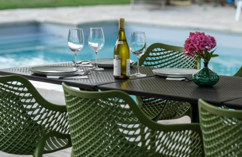 einen Tisch mit Gläsern und eine Flasche Wein in der Unterkunft Relais M B&B in Frasnes-lez-Anvaing