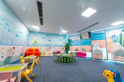 a kindergarten with tables and chairs in a room with colorful walls at Sanya Conifer Resort in Sanya