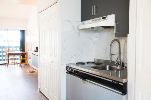 a kitchen with a sink and a stove at Sand Pebbles Inn in Qualicum Beach