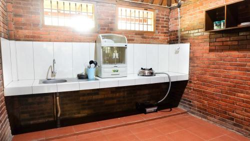 a kitchen with a sink in a brick wall at Villa Karang Kedempel Bandungan SimplyHomy in Semarang