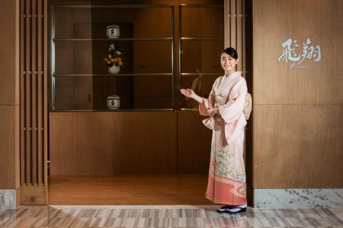 a woman in a kimono standing in a room at Hotel Nikko Hai Phong in Hai Phong