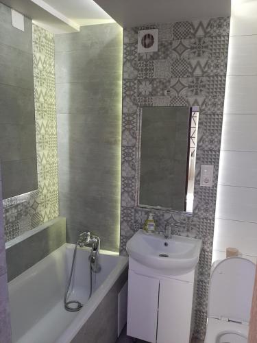 ein Badezimmer mit einem Waschbecken, einer Badewanne und einem WC in der Unterkunft Люкс1 in Uschhorod