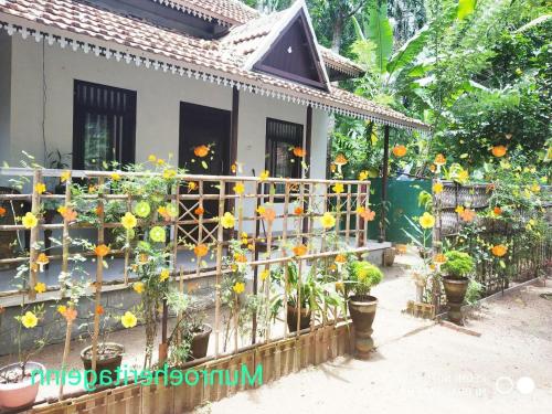 a house with flowers on a fence at Munroe Heritage Inn in Munroe Island