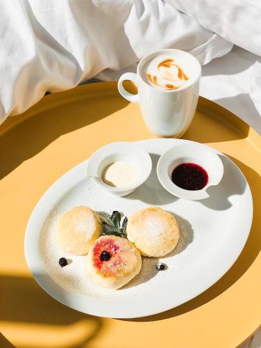 a plate of food and a cup of coffee on a table at Opera Passage Hotel & Apartments in Lviv