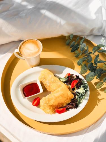 a plate of food and a cup of coffee at Opera Passage Hotel & Apartments in Lviv