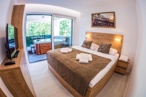 sypialnia z dużym łóżkiem i dużym oknem w obiekcie Penthouse apartments w Trzcianie