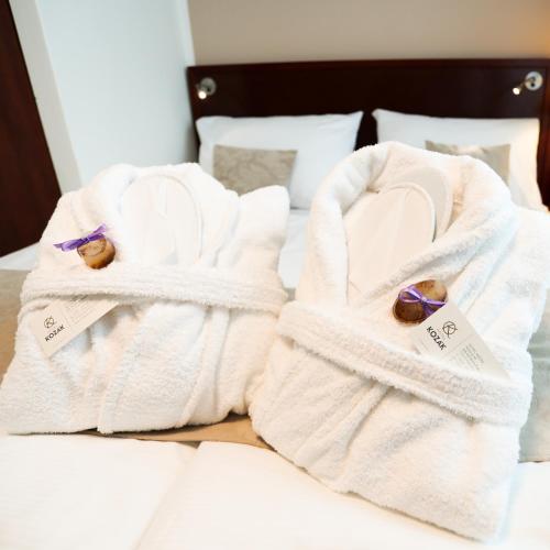 two towels sitting on top of a bed at Hotel KOZÁK in Brno