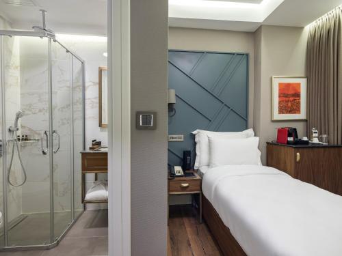 a hotel room with a bed and a shower at Azzap Hotel Galata in Istanbul