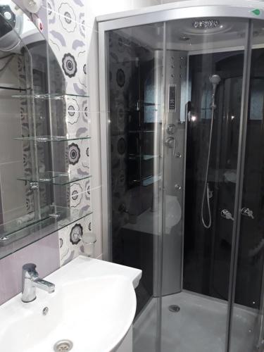 a bathroom with a shower and a toilet and a sink at Къща за гости Динас in Zmeitsa