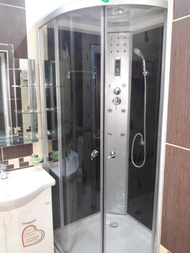 a shower with a glass door in a bathroom at Къща за гости Динас in Zmeitsa