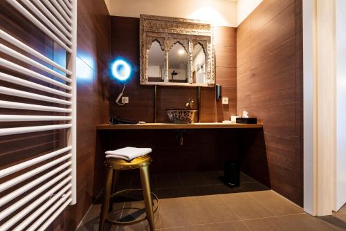 a bathroom with a stool and a mirror at Blackhome Graz I contactless check-in in Graz