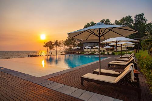 basen z leżakami i parasolami oraz ocean w obiekcie Chen Sea Resort & Spa Phu Quoc w Duong Dong