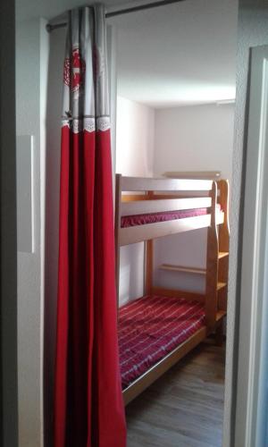a room with two bunk beds with a red curtain at Vos vacances à Albiez Montrond in Albiez-Montrond