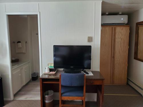Habitación con escritorio y TV. en Alaska Country Inn, en Delta Junction