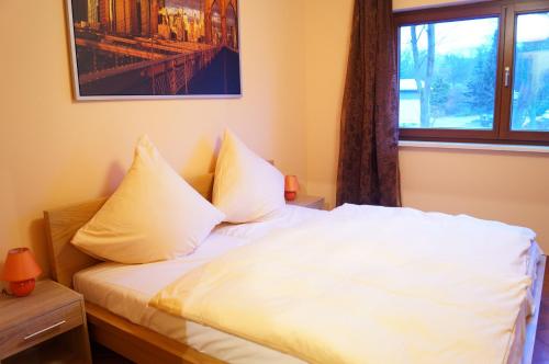 a bedroom with a bed with white sheets and a window at Boutique Hotel Sena in Berlin