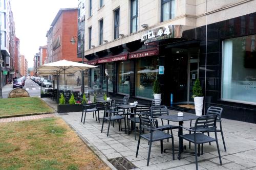 a row of tables and chairs outside of a restaurant at Hotel 44 in Gijón