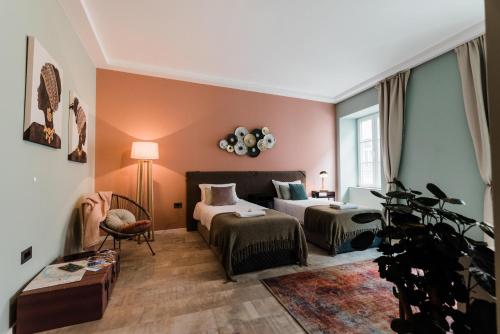 a hotel room with two beds and a couch at Square 19-Boutique hotel in Novi Sad