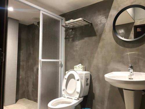 a bathroom with a toilet and a sink and a mirror at No. 36 Farm in Hualing