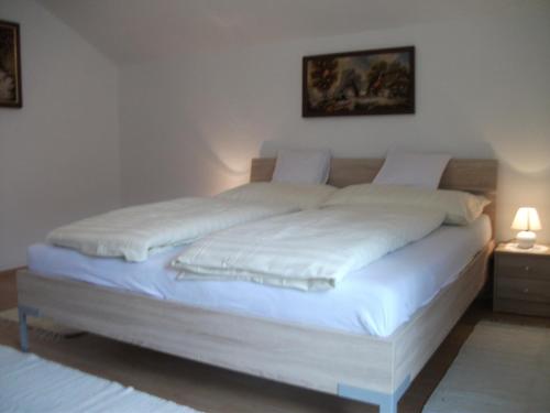 a white bed in a room with a night stand at Ferienhaus Gassner in Navis