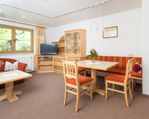 a dining room with a table and chairs and a tv at Haus Dietmar in Holzgau