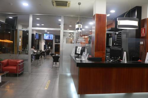 a bar in a restaurant with a person sitting at a table at Hotel 44 in Gijón