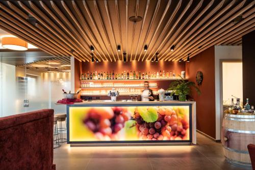 a bar with a painting of fruit on it at Hotel Winzerhof in Termeno