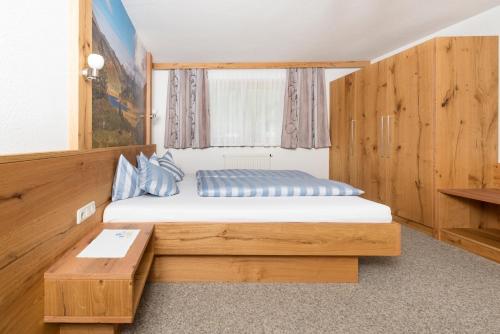 ein kleines Schlafzimmer mit einem Bett und einem Tisch in der Unterkunft Haus Dietmar in Holzgau