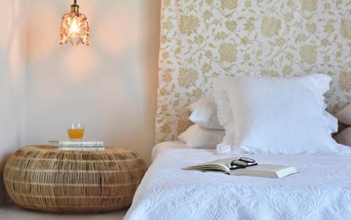 a bedroom with a bed with a book and a lamp at Elefthia Syros Exclusive Suite in Megas Yialos-Nites