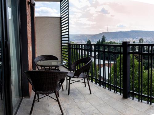 a balcony with chairs and a table and a view at TM Apart Hotel in Tbilisi City