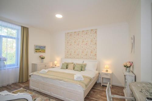 a bedroom with a bed with two tables and a window at Villa Bella in Badacsonytomaj