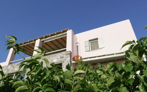a white building with trees in front of it at Angeliki House by Elefthia Syros in Megas Yialos-Nites
