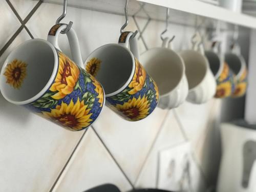 a row of coffee cups hanging on a wall at Unique Anoi House - In the Heart of Skyros Village in Skiros