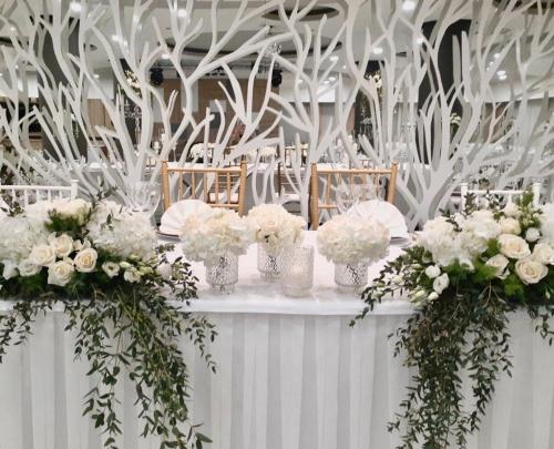 a table with white flowers in vases on it at Hotel Bellevue in Trebinje
