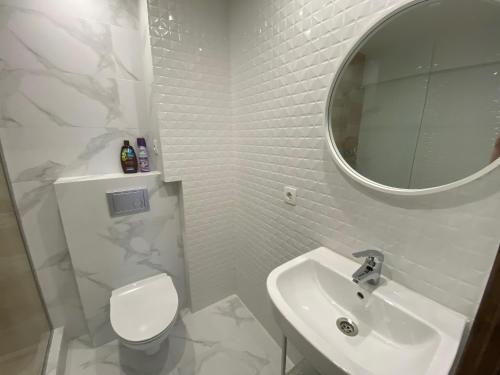 a white bathroom with a sink and a mirror at Квартира подобово на Площі Ринок 39 in Lviv