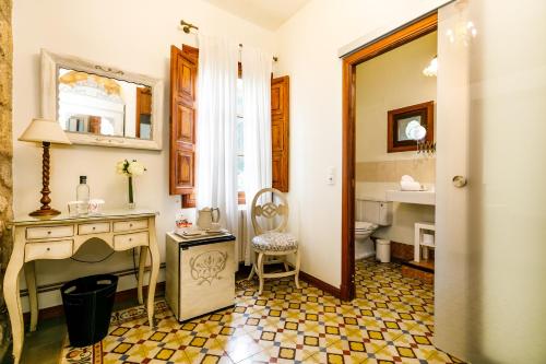 a bathroom with a sink and a desk and a toilet at Finca Cas Sant in Sóller