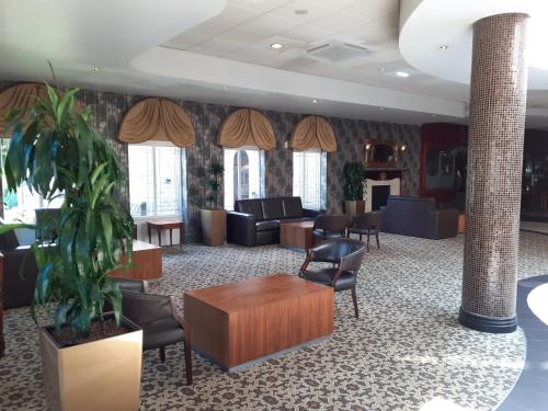 a lobby with a waiting room with couches and chairs at Holiday Inn Barnsley by IHG in Barnsley