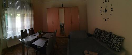 a living room with a couch and a table and a cabinet at Váralja Vendégház Tata in Tata