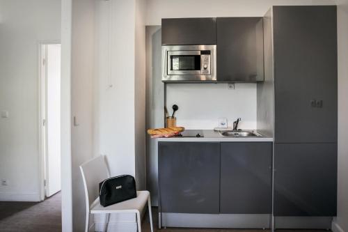 a small kitchen with a sink and a microwave at Comfort Aparthotel Lourdes Lorda in Lourdes