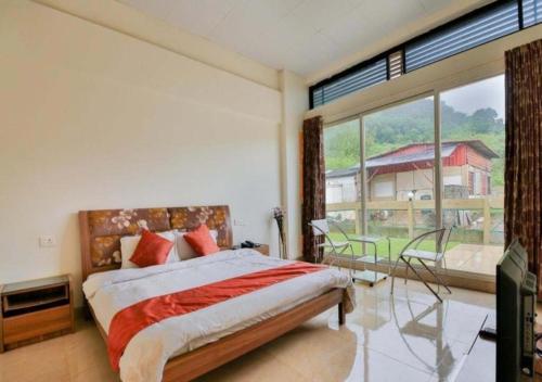 a bedroom with a bed and a large window at Rainforest Resort and Spa, Igatpuri in Igatpuri