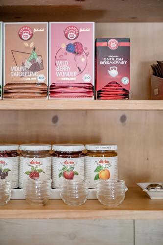 Un estante con frascos de comida y libros. en Corso`s Annabell - Bed & Breakfast, en Sölden