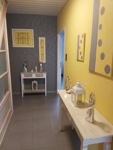 a kitchen with yellow walls and a table and a sink at El Corazon in Stavelot