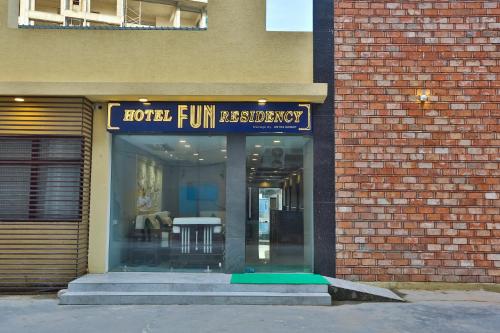 a store with a sign on the front of a brick building at Hotel Fun Residency by Antra Group in Ahmedabad