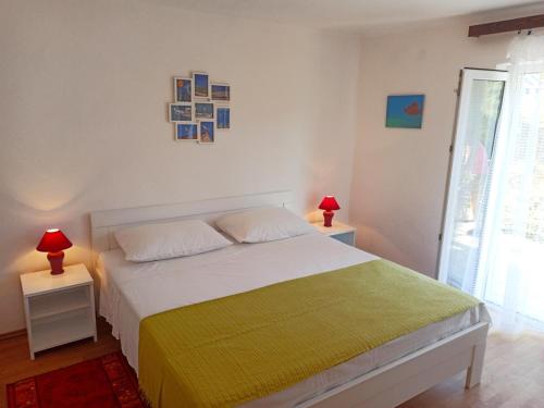 een slaapkamer met een bed en 2 tafels met lampen bij Apartments Sonija in Gdinj