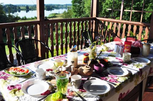 a table with plates of food on a balcony at Gospodarstwo Agroturystyczne Rowerowa Przystań "Jankesówka" in Lidzbark Warmiński